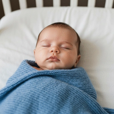 Cute baby sleeping peacefully in a safe cot bed