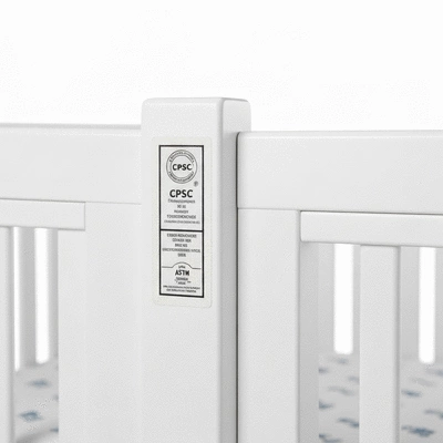 CPSC and ASTM certification labels on a crib in a well-lit studio